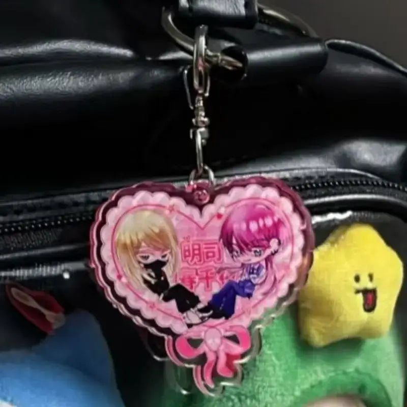 Pink heart-shaped acrylic keychain featuring tokyo revengers anime characters with decorative bow at the bottom