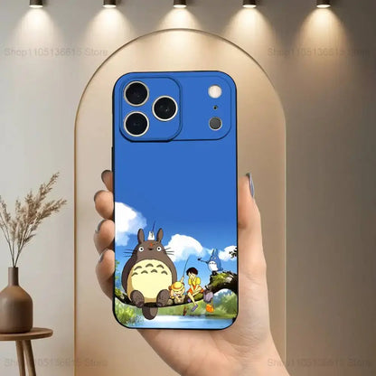 Blue totoro-themed soft silicone phone case in black featuring vibrant character illustration against sky backdrop