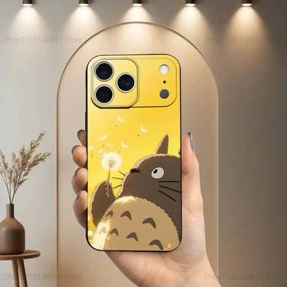 Yellow totoro-themed soft silicone phone case with cartoon blowing dandelion seeds on black cover back side