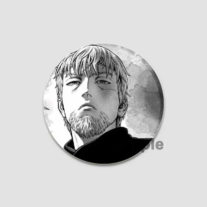 Circular black and white vinland saga anime badge pin featuring a detailed character illustration on tinplate plastic