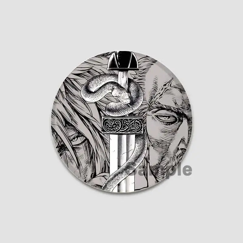 Circular black-and-white vinland saga anime badge pin featuring a sword with ornate hilt coiled by a snake and faces