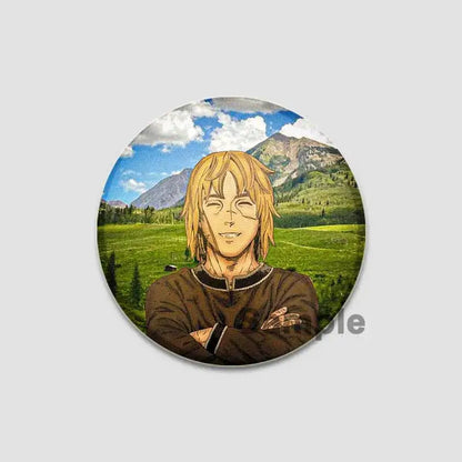 Circular vinland saga anime badge pin featuring a blonde character with crossed arms against a mountain backdrop