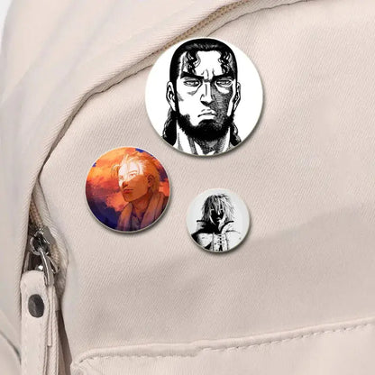 Three circular vinland saga anime badge pins featuring black-and-white bearded man and blonde figure on tinplate plastic