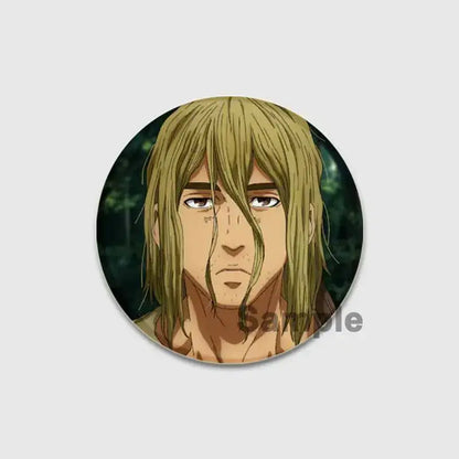 Circular vinland saga badge pin featuring an anime character with long light brown hair on a dark forest background