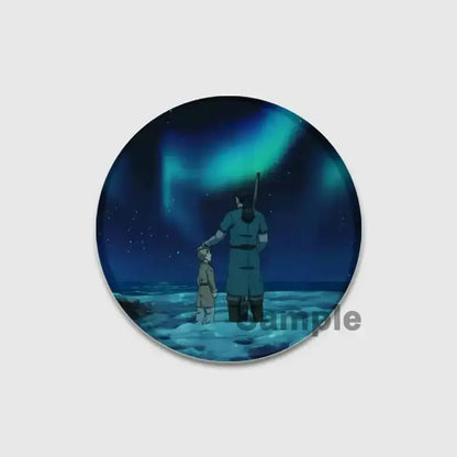 Circular acrylic vinland saga badge pin showing a tall figure and child on icy terrain under green aurora