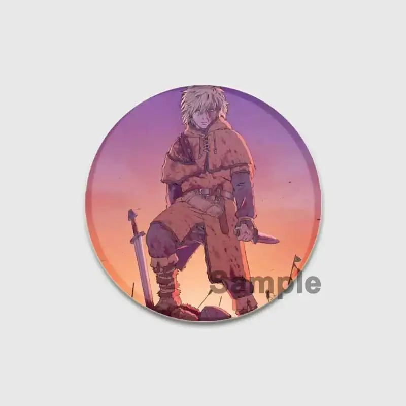 Circular vinland saga badge pin featuring a white-haired character in a brown hood holding sword and dagger at sunset