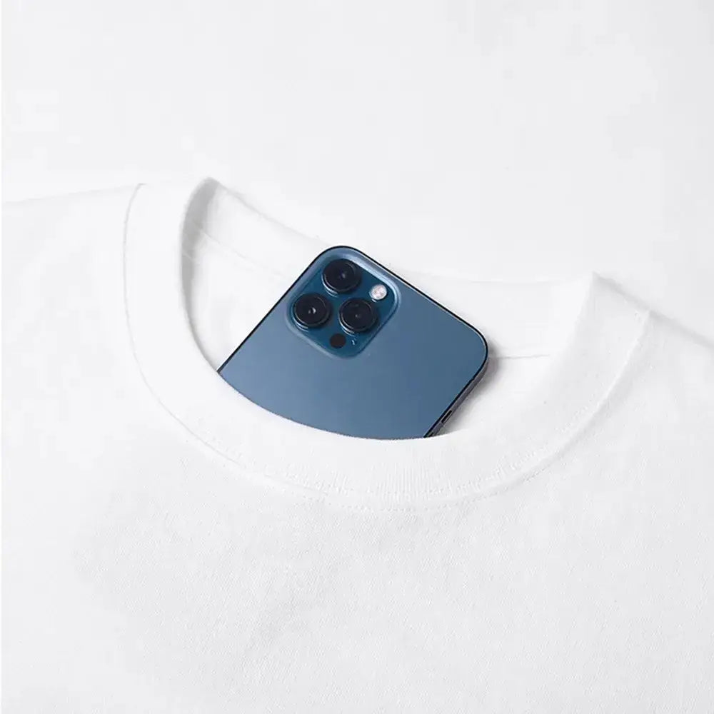 A sleek deep blue iphone 12 pro with triple-camera rests in the neckline of a y2k vinland saga t-shirt featuring thorfinn and askeladd