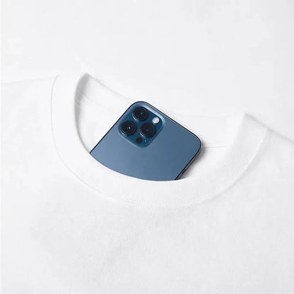 A sleek deep blue iphone 12 pro with triple-camera rests in the neckline of a y2k vinland saga t-shirt featuring thorfinn and askeladd