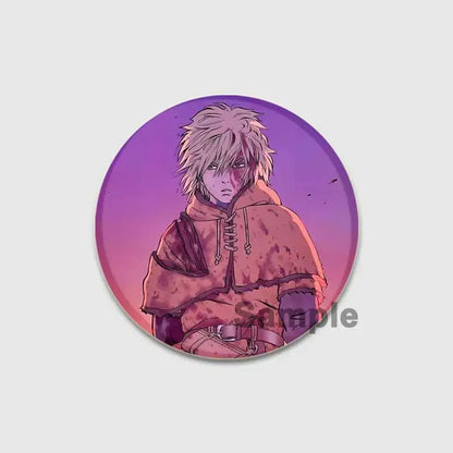 Circular vinland saga thorfinn button brooch featuring anime character with spiky white hair and blood-stained hooded cloak