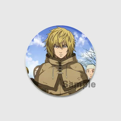 Circular vinland saga thorfinn enamel pin featuring an anime character with spiky blonde hair and tan hooded cloak
