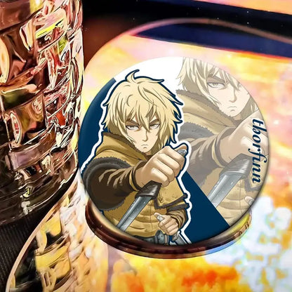 Circular vinland saga thorfinn lapel pin featuring blonde anime character with two swords on dark blue background
