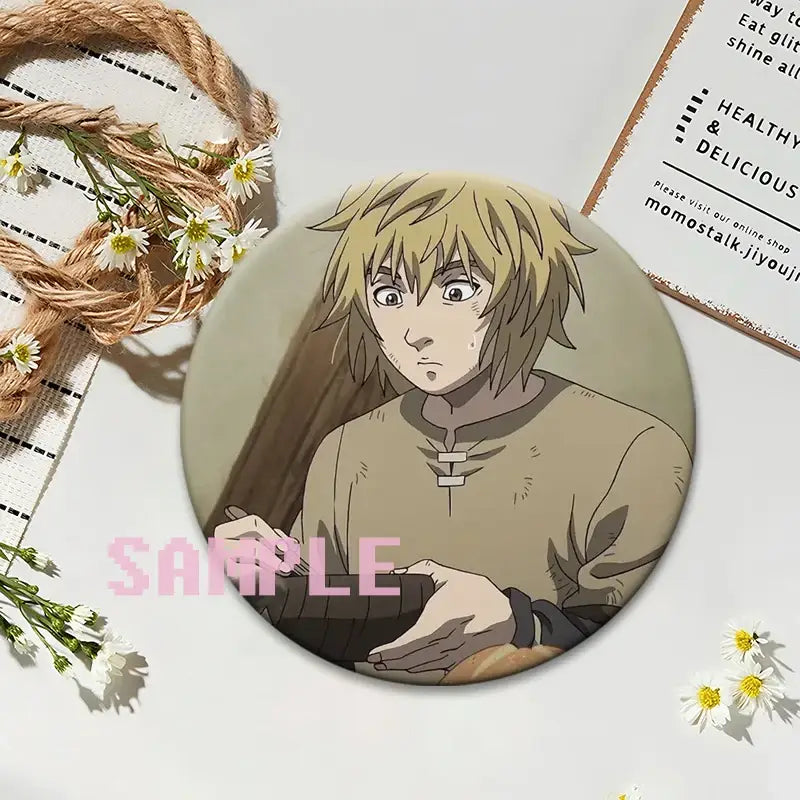 Circular vinland saga thorfinn lapel pin featuring anime character with light brown hair on smooth plastic badge