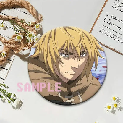 Circular vinland saga thorfinn lapel pin featuring an anime character with blonde hair in a brown hooded outfit