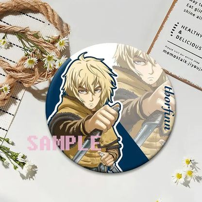 Circular vinland saga thorfinn lapel pin featuring blonde anime character holding two swords on blue background