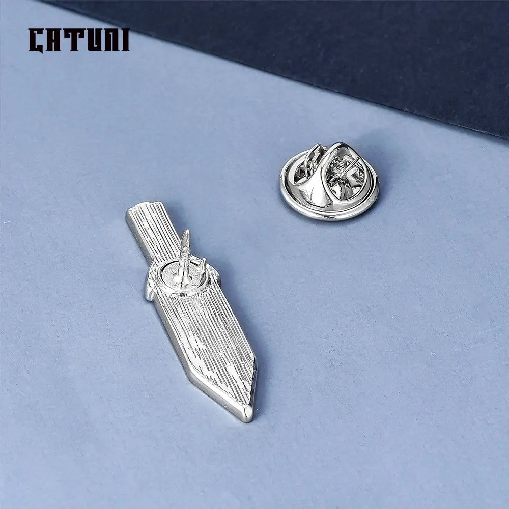 Silver metallic vinland saga thorfinn pin brooch shaped like stylized sword with engraved vertical lines on blade