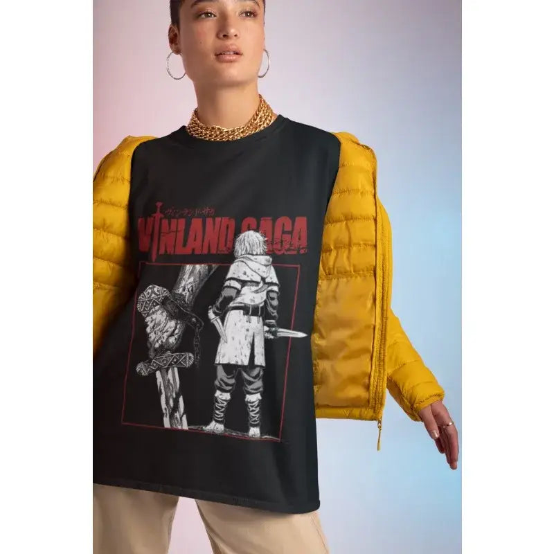 Black vinland saga cotton tee with bold red lettering and warrior illustration worn over mustard-yellow vest