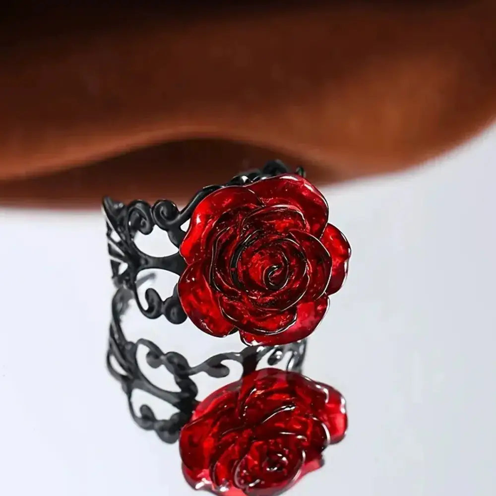 Black metal vine ring with a glossy red rose centerpiece and intricate scrollwork in gothic vintage style