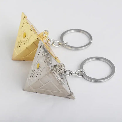 Two pyramid-shaped alloy keychains in gold and silver with detailed engravings and yellow gemstones for pendant necklace use